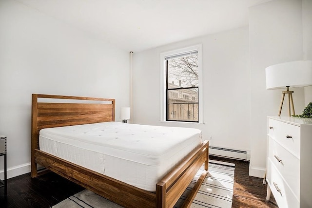 bedroom with baseboard heating and dark hardwood / wood-style flooring