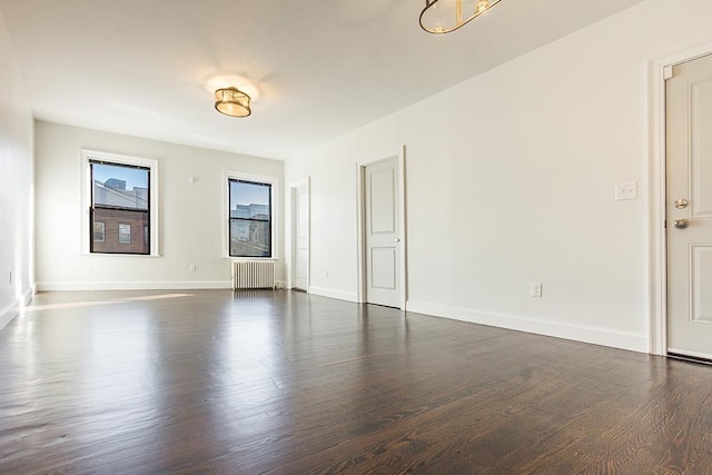 empty room with radiator heating unit and dark wood-type flooring