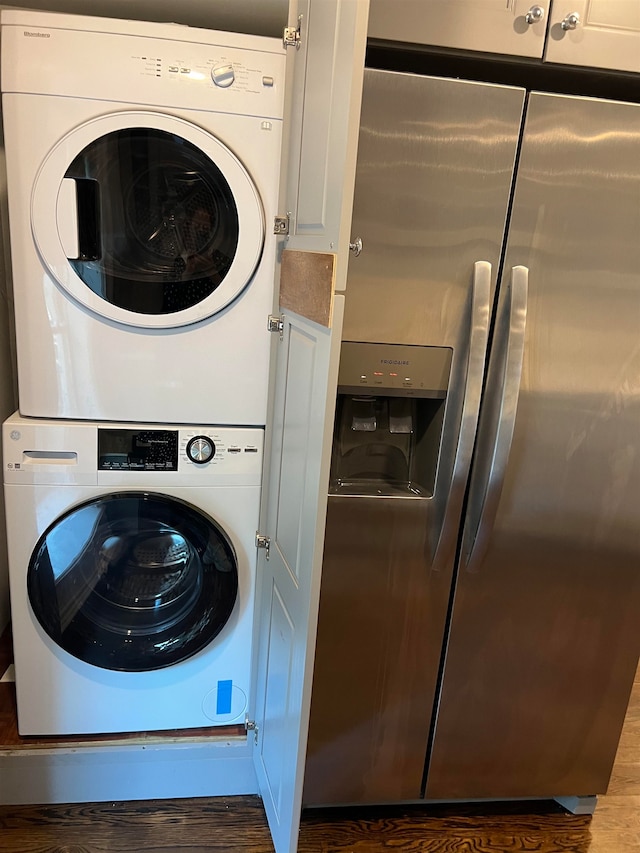 washroom featuring wood-type flooring and stacked washer / dryer