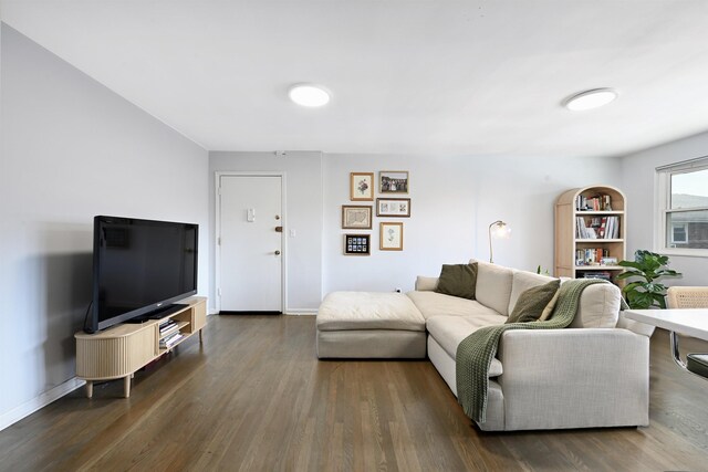 living room featuring dark wood-type flooring and baseboards