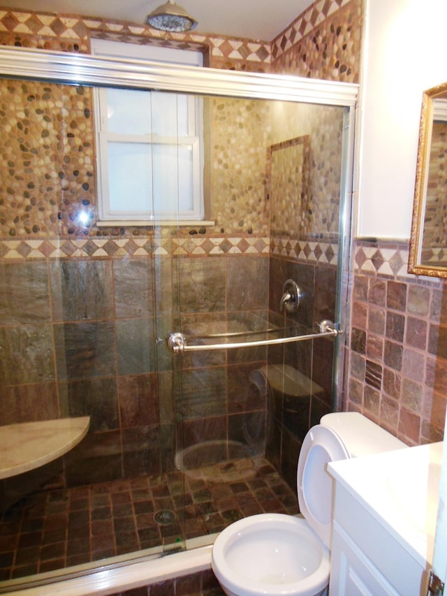 bathroom with vanity, toilet, tile walls, and walk in shower