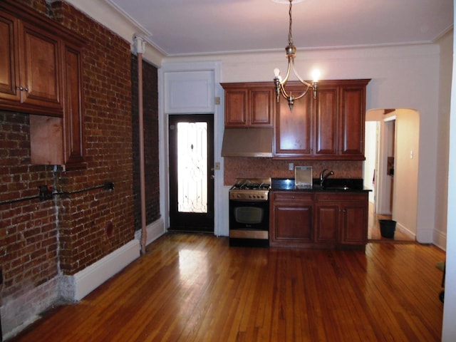 kitchen featuring sink, dark hardwood / wood-style floors, crown molding, exhaust hood, and stainless steel range with gas stovetop