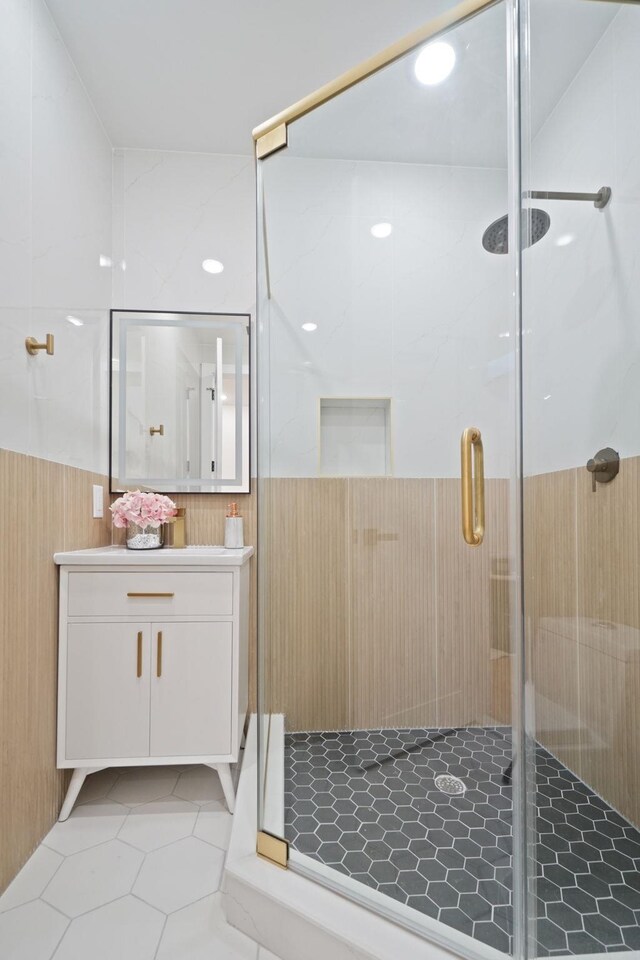 bathroom with walk in shower, tile patterned flooring, and vanity