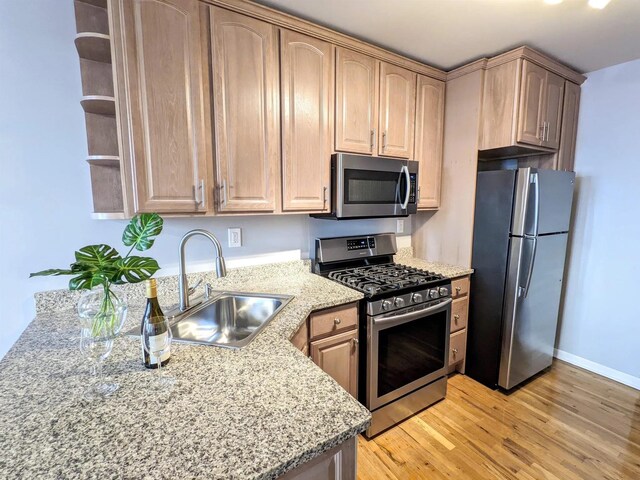 124 Madison St Unit 3L, Hoboken, NJ 07030 - kitchen featuring stainless steel appliances, a sink, light wood-style floors, light stone counters, and open shelves