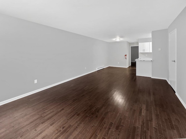 unfurnished living room with a baseboard radiator, dark wood finished floors, and baseboards