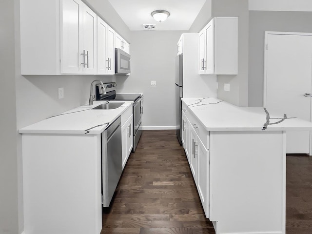 kitchen featuring dark wood finished floors, white cabinetry, stainless steel appliances, and a sink