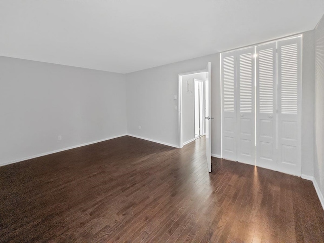 unfurnished bedroom with dark wood-style floors and baseboards