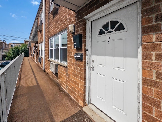 doorway to property with brick siding and a balcony