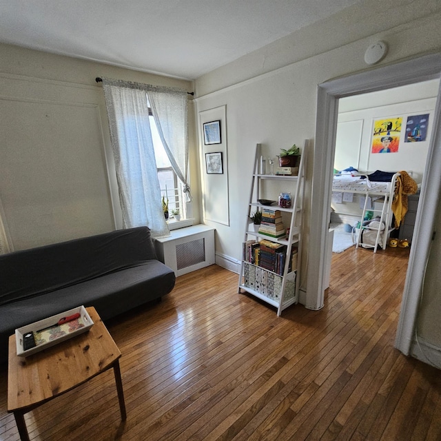 living area featuring hardwood / wood-style flooring and radiator