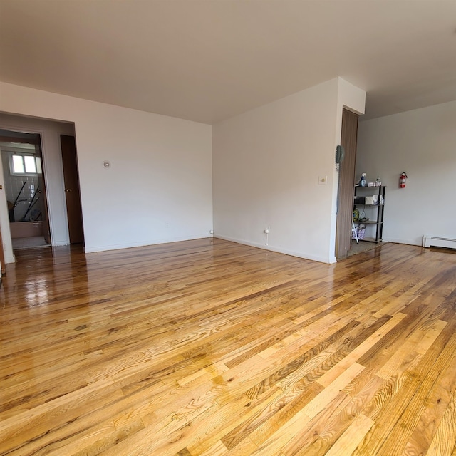 interior space featuring a baseboard heating unit and light hardwood / wood-style floors