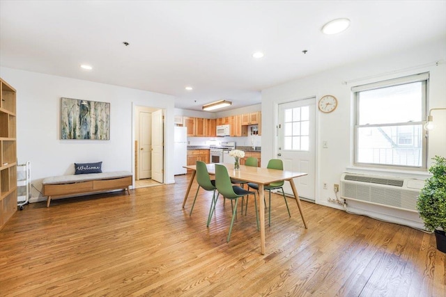 dining area with recessed lighting, an AC wall unit, and light wood finished floors