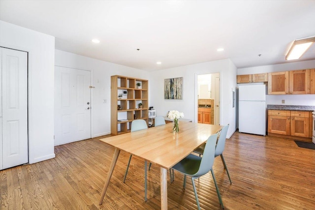 dining space with recessed lighting, baseboards, and light wood finished floors