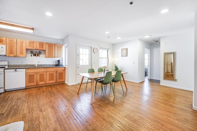 kitchen with light wood finished floors, recessed lighting, white appliances, and a sink