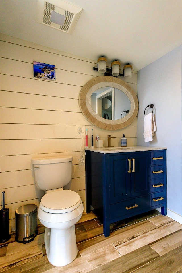123 Willow Ter, Hoboken, NJ 07030 - bathroom featuring wood finished floors, toilet, vanity, and wood walls