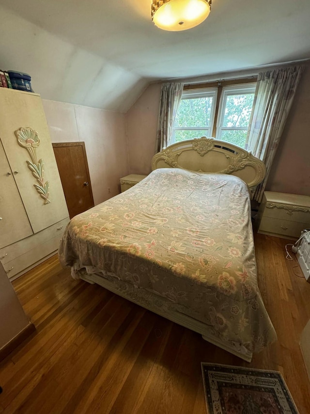 bedroom with hardwood / wood-style floors and vaulted ceiling