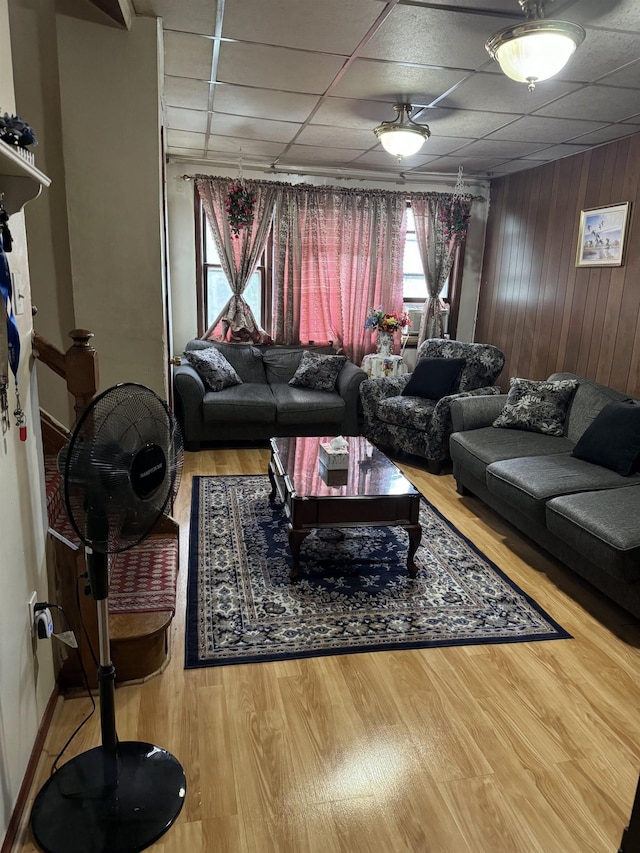 living room with a paneled ceiling and wood-type flooring