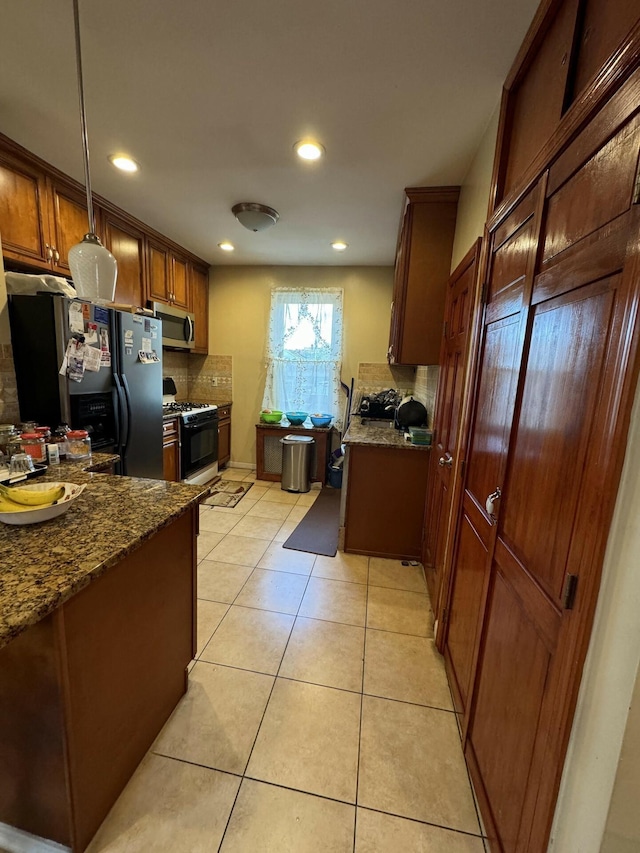 kitchen with backsplash, dark stone counters, decorative light fixtures, light tile patterned flooring, and appliances with stainless steel finishes