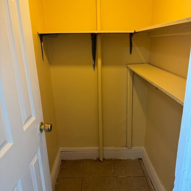 spacious closet featuring dark tile patterned flooring