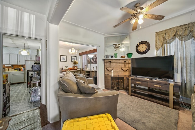 living room with a brick fireplace, carpet floors, and ceiling fan with notable chandelier