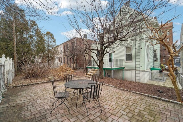 view of patio / terrace featuring a fenced backyard, a trampoline, and outdoor dining space