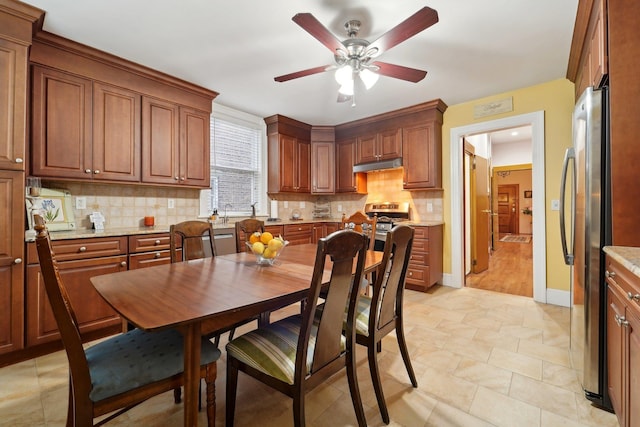 dining space featuring ceiling fan and baseboards