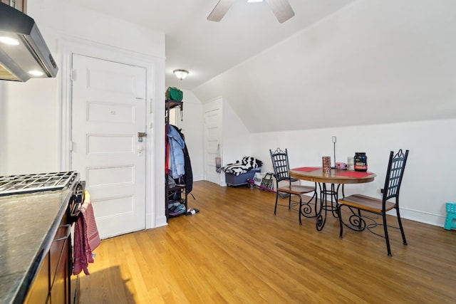 dining room with a ceiling fan, light wood finished floors, and lofted ceiling