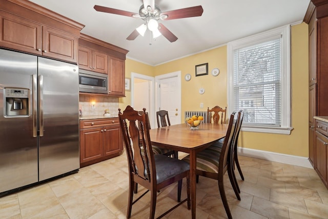 dining area with a ceiling fan, baseboards, and ornamental molding
