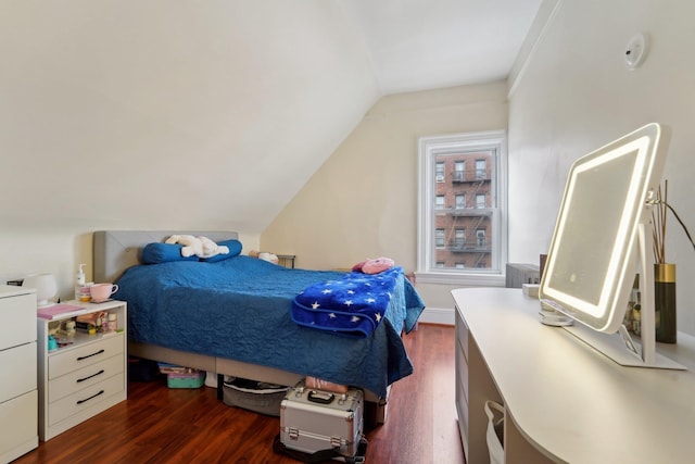 bedroom with vaulted ceiling and dark wood-style flooring