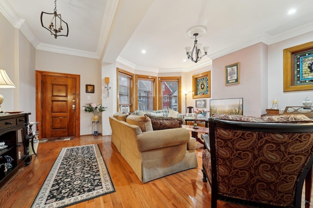 living room with wood-type flooring, recessed lighting, crown molding, and an inviting chandelier