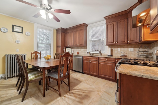 kitchen featuring stainless steel dishwasher, a sink, radiator heating unit, tasteful backsplash, and a ceiling fan