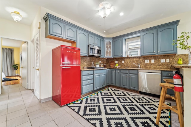 37 47th St, Weehawken, NJ 07086 - kitchen with appliances with stainless steel finishes, backsplash, light tile patterned floors, and a sink