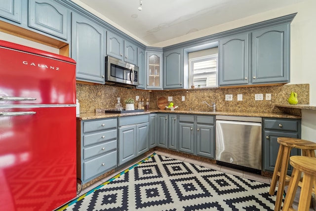 37 47th St, Weehawken, NJ 07086 - kitchen featuring stainless steel appliances, decorative backsplash, glass insert cabinets, and gray cabinets