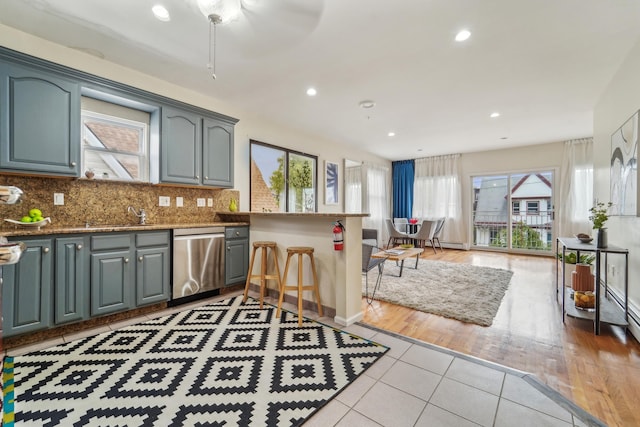 37 47th St, Weehawken, NJ 07086 - kitchen with stainless steel dishwasher, light tile patterned floors, tasteful backsplash, a peninsula, and stone countertops