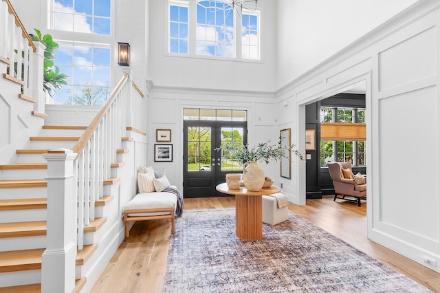 150 Mountain Ave, Pequannock Township, NJ 07444 - living area with a towering ceiling, stairs, a decorative wall, wood finished floors, and french doors