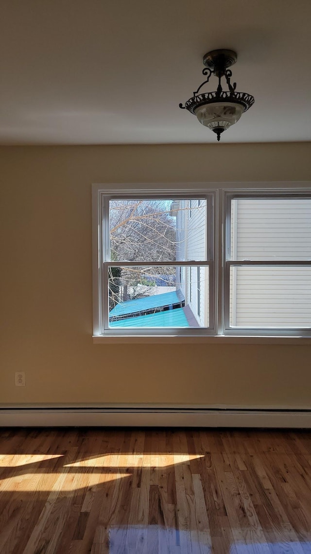 interior details featuring baseboard heating and wood finished floors