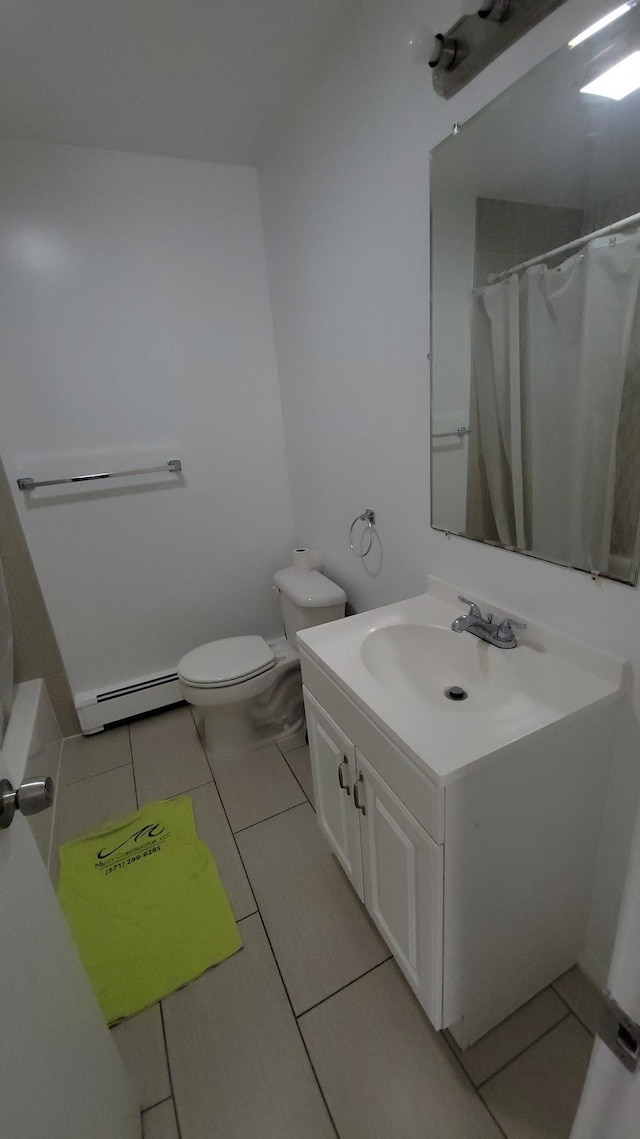 bathroom with a baseboard radiator, toilet, vanity, and tile patterned flooring