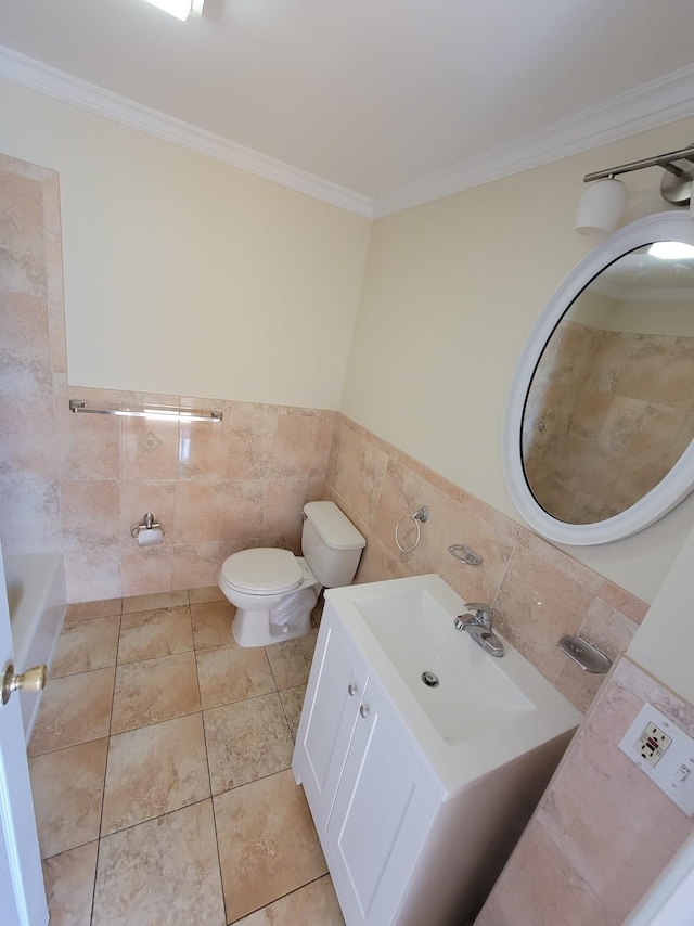 bathroom with tile patterned floors, toilet, tile walls, crown molding, and vanity