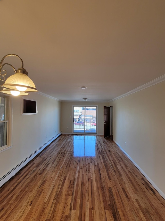 empty room with a baseboard radiator, wood finished floors, baseboards, and ornamental molding