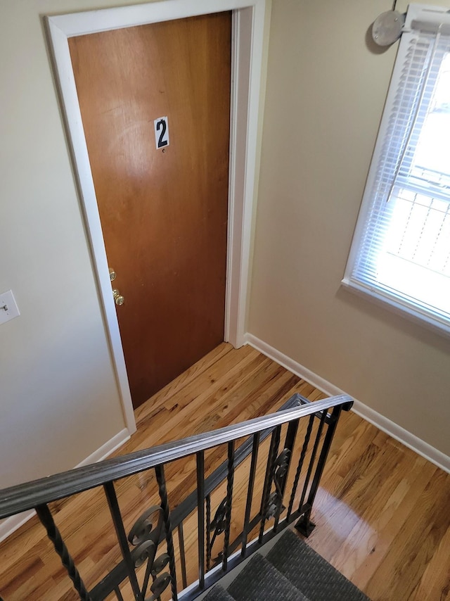 staircase featuring wood finished floors and baseboards