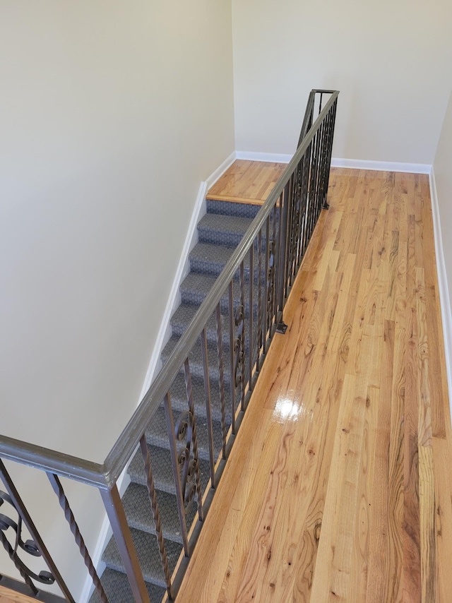 staircase featuring baseboards and wood finished floors