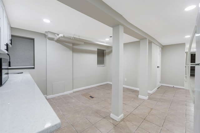 finished basement featuring baseboards, light tile patterned flooring, and recessed lighting