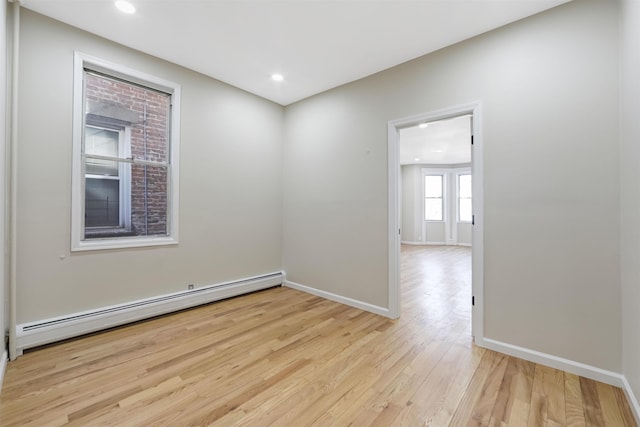 spare room featuring light wood-style floors, a baseboard radiator, baseboards, and recessed lighting