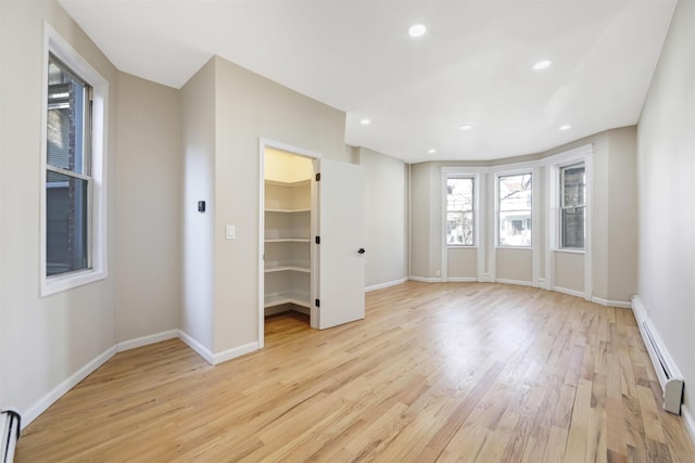 interior space with light wood-type flooring, a baseboard radiator, baseboards, and recessed lighting