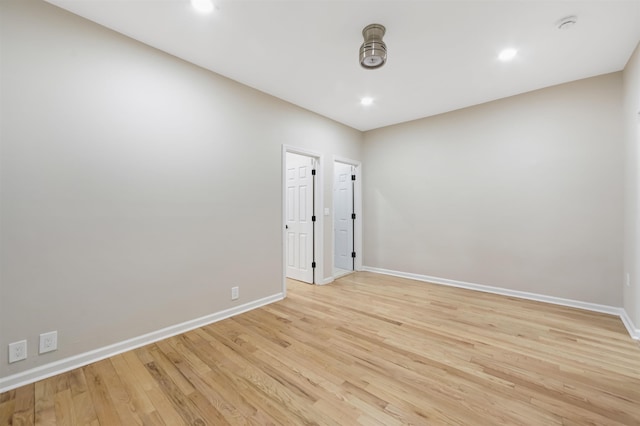 unfurnished room featuring light wood-style flooring, baseboards, and recessed lighting