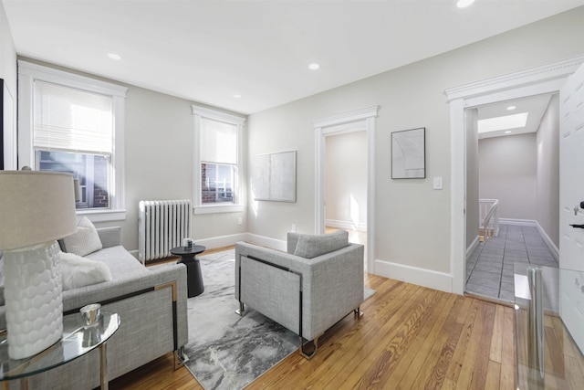 living room featuring radiator heating unit, recessed lighting, wood finished floors, and baseboards