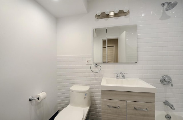 bathroom featuring shower / washtub combination, tile walls, vanity, and toilet