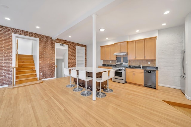 kitchen with visible vents, light wood-style flooring, a breakfast bar area, a center island, and stainless steel appliances