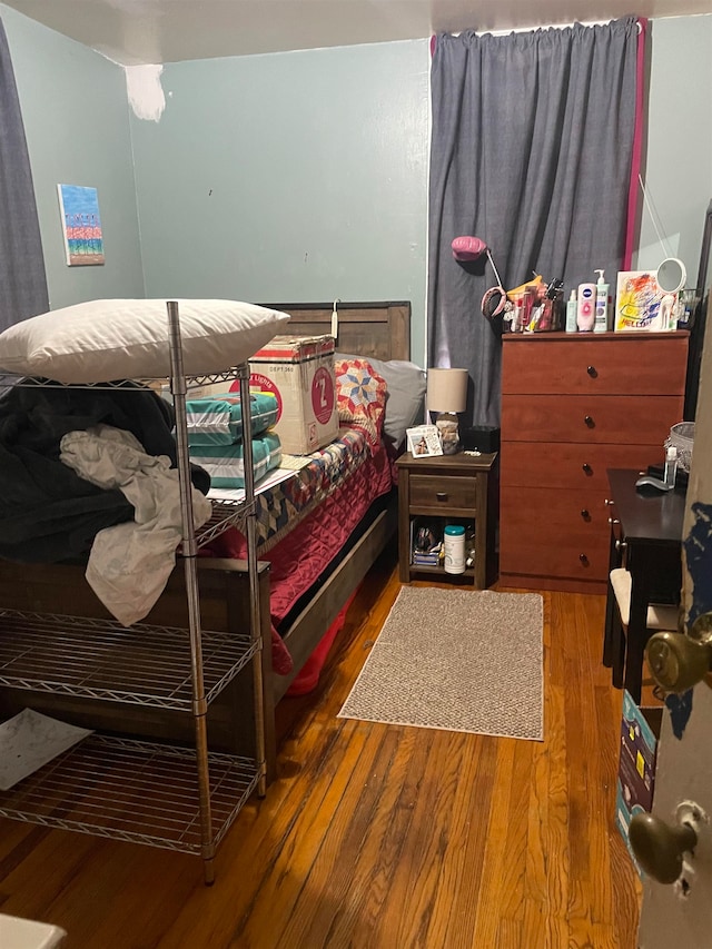 bedroom with dark hardwood / wood-style flooring