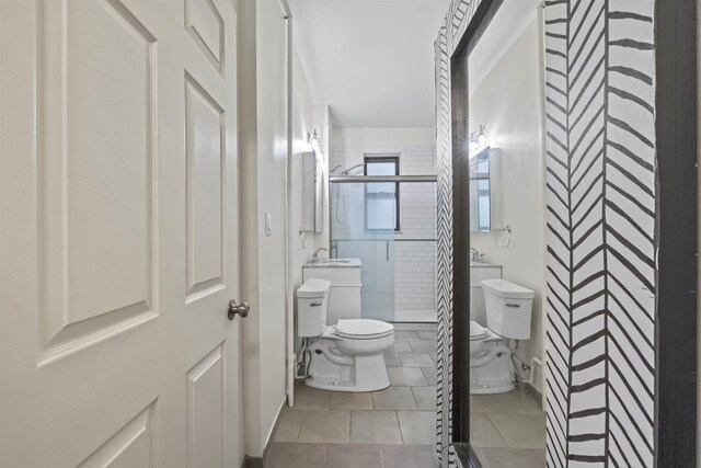 bathroom with toilet, a shower stall, and tile patterned floors