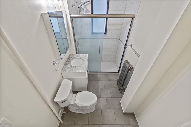 bathroom featuring a shower stall, toilet, tile patterned flooring, radiator heating unit, and vanity
